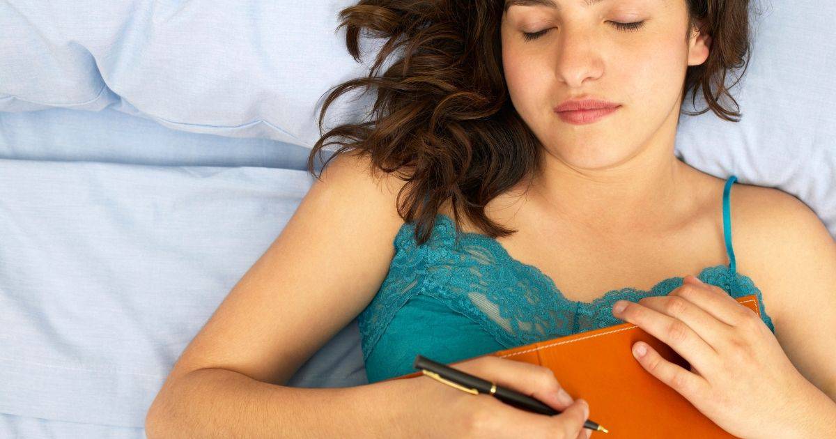 woman in bed with sleep diary